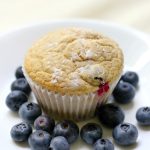 plated gluten-free blueberry muffin with extra scattered fresh blueberries