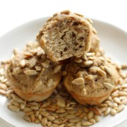 three banana sunflower mini muffins on a plate with sunflower seeds