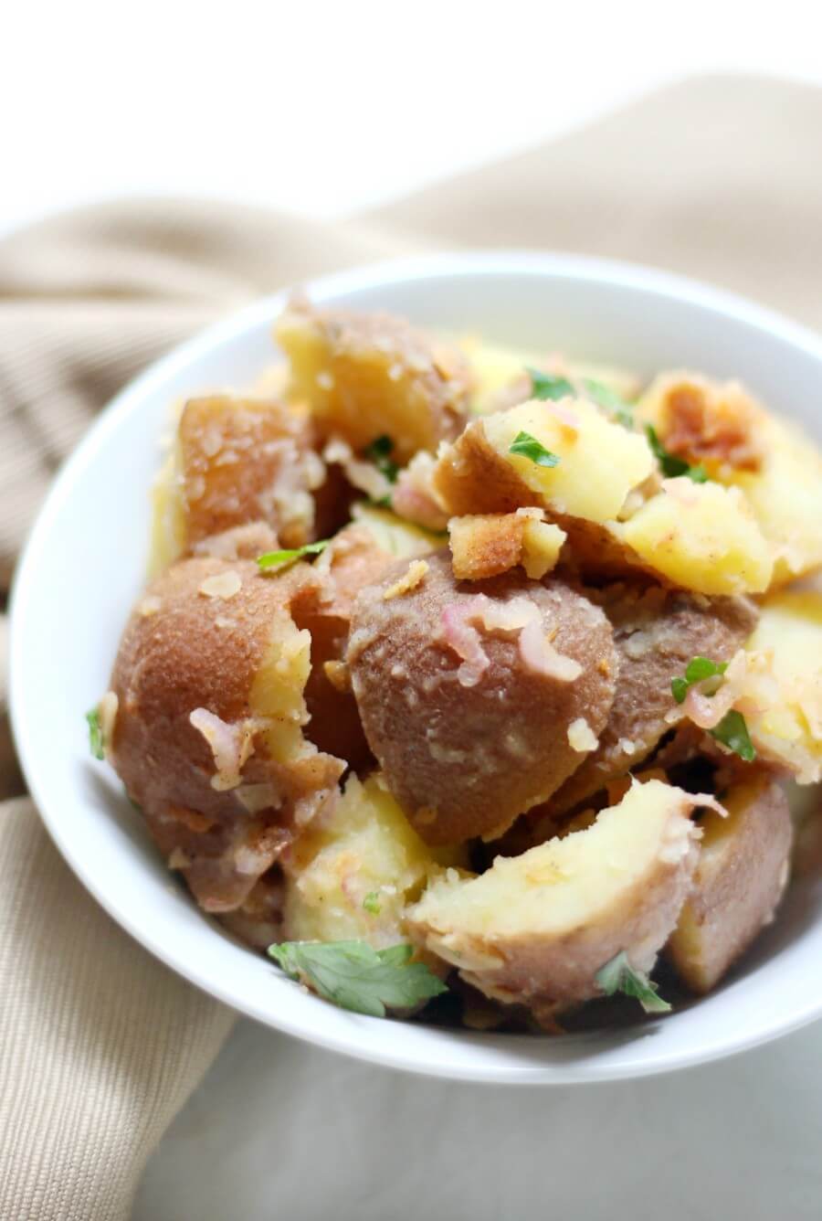 single white bowl of vegan german potato salad