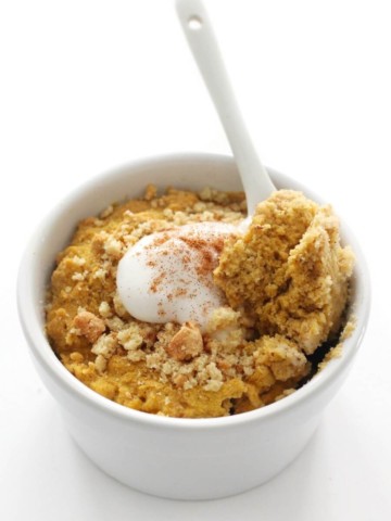 white spoon scoop of gluten-free pumpkin mug cake with toppings