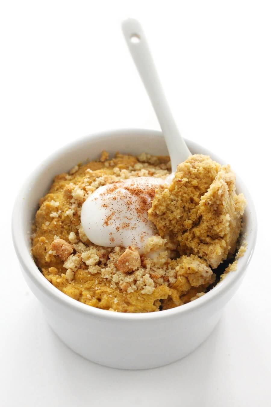 white spoon scoop of gluten-free pumpkin mug cake with toppings