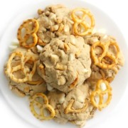 overhead view of loaded vegan white chocolate chip pretzel cookies on a plate