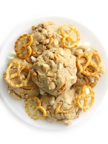 overhead view of loaded vegan white chocolate chip pretzel cookies on a plate
