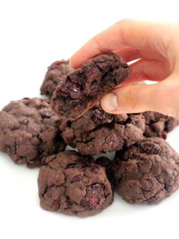hand holding half eaten gluten-free chocolate cherry cookie