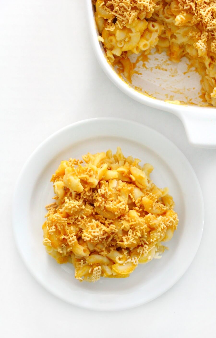 overhead view of plated baked vegan mac & cheese with casserole dish