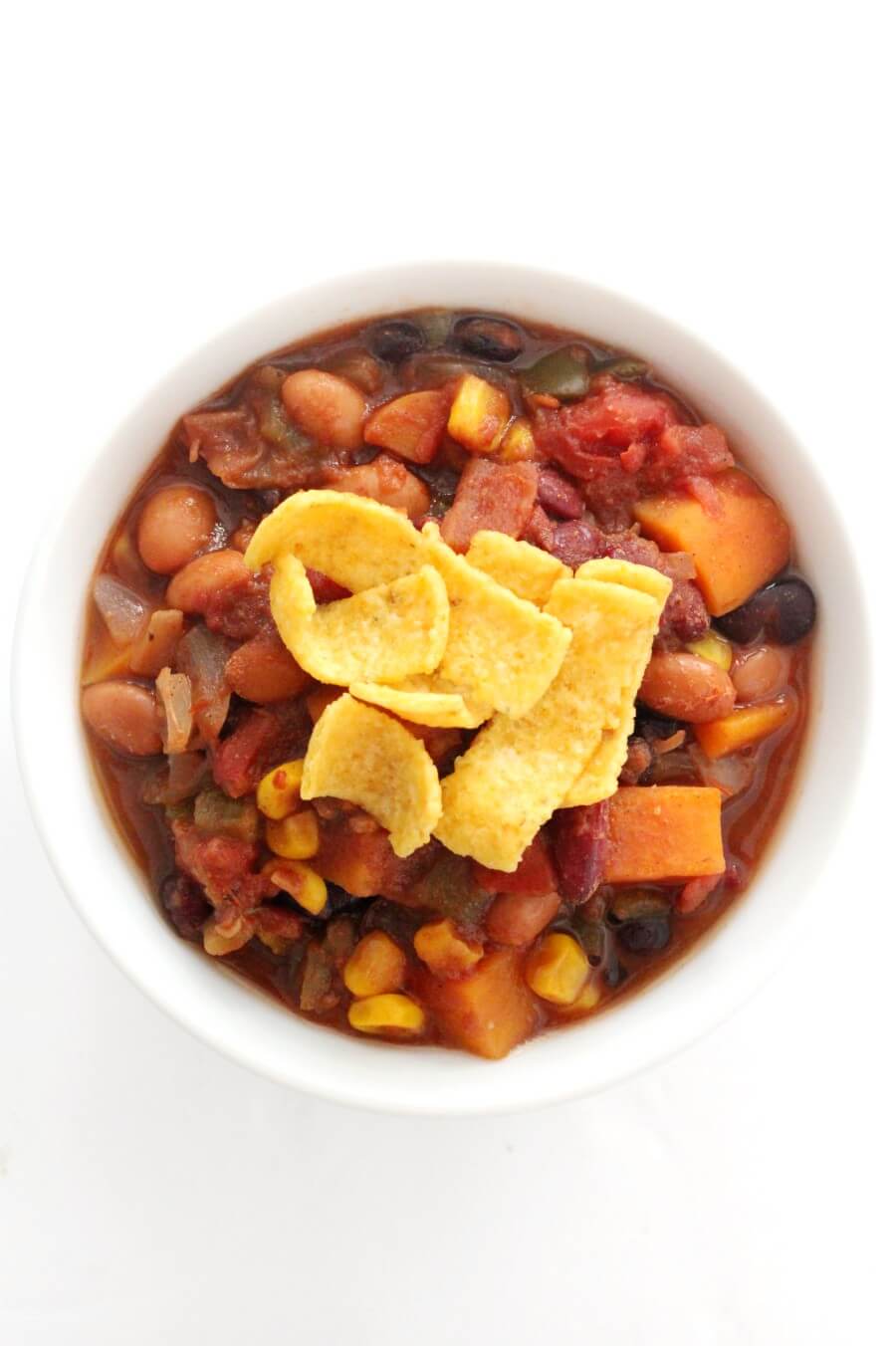 overheat view of slow cooker vegetarian chili in a bowl with corn chips