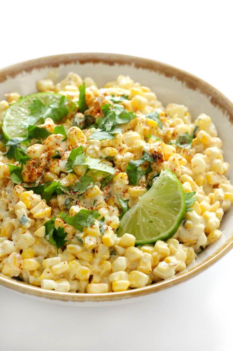 bowl of vegan mexican street corn salad with lime slices