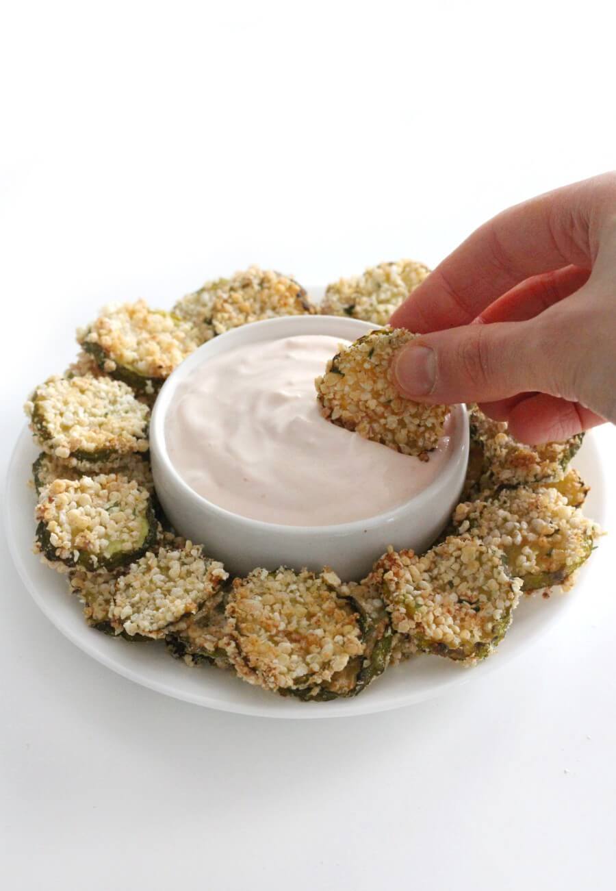 hand dipping a gluten-free air fryer fried pickle in creamy ketchup dip