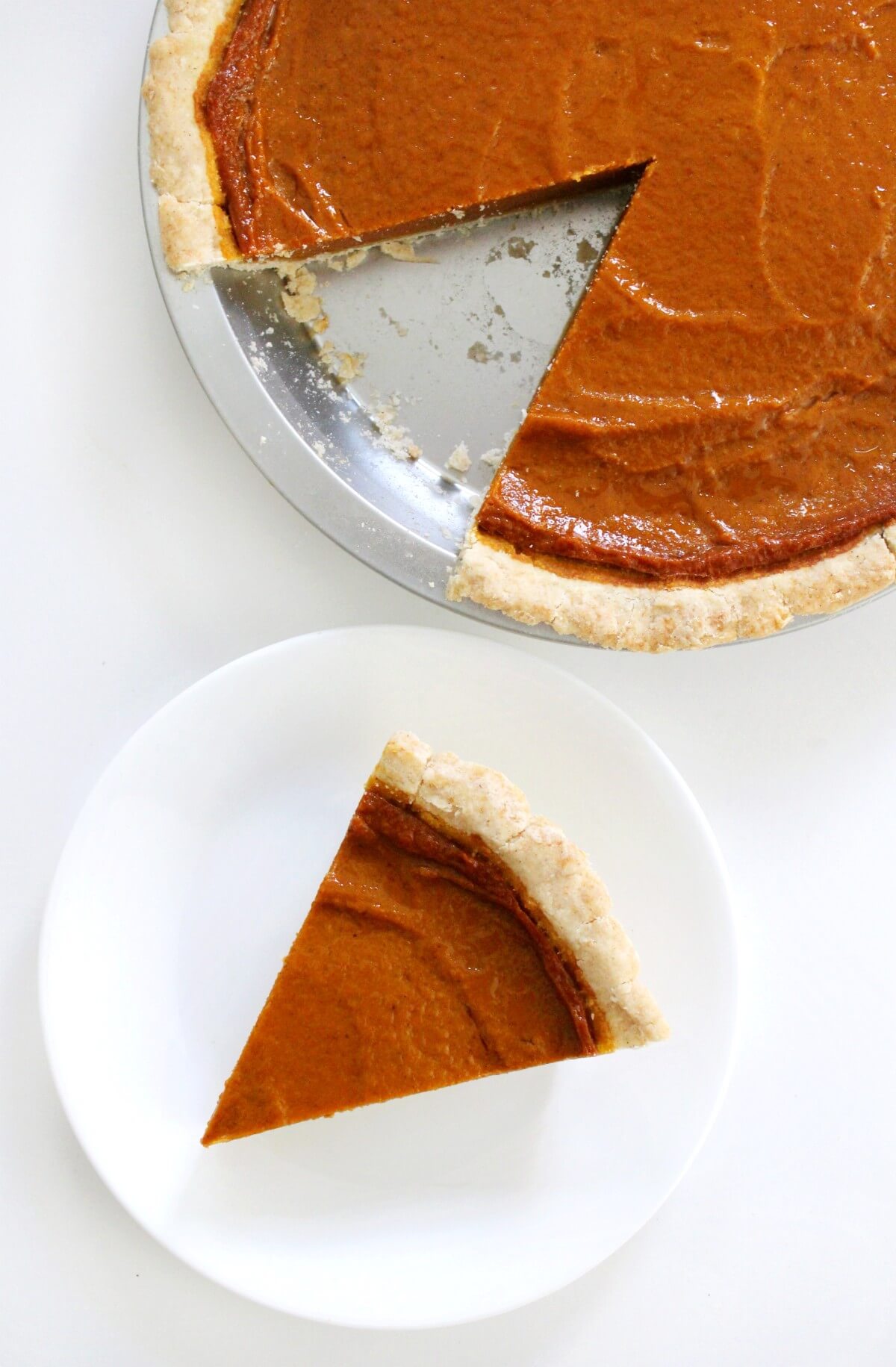 overhead shot of gluten-free vegan pumpkin pie with slice cut out on plate