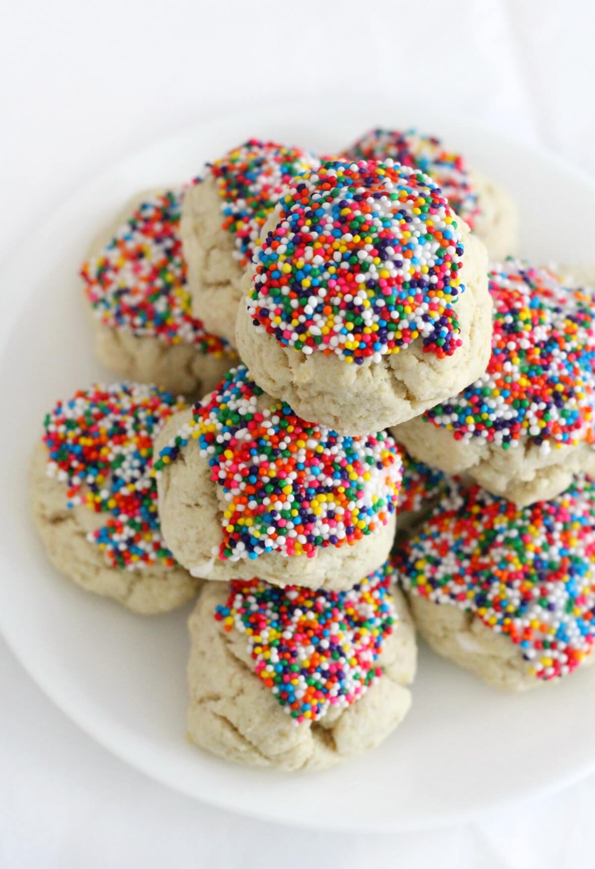 stacked gluten-free anisette cookies on white plate