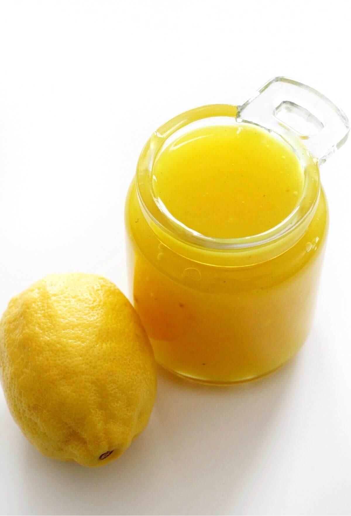 jar of vegan lemon curd next to whole lemon
