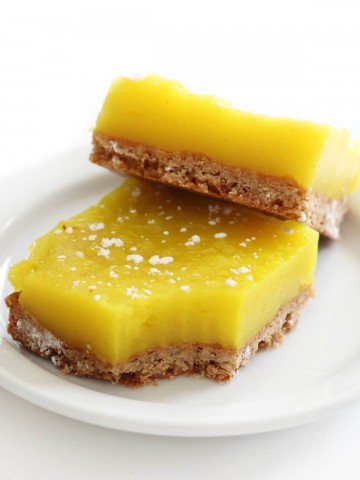two vegan lemon bars on a white plate