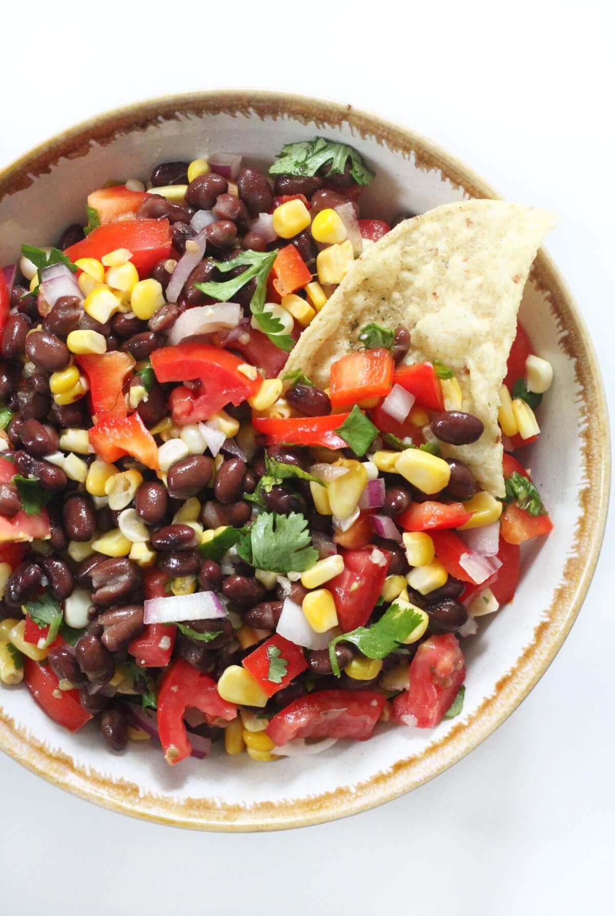 black bean and corn salsa with tortilla chip in bowl