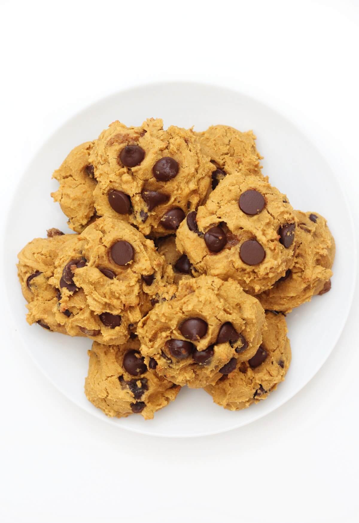 overhead view of white plate piled with pumpkin chocolate chip cookies