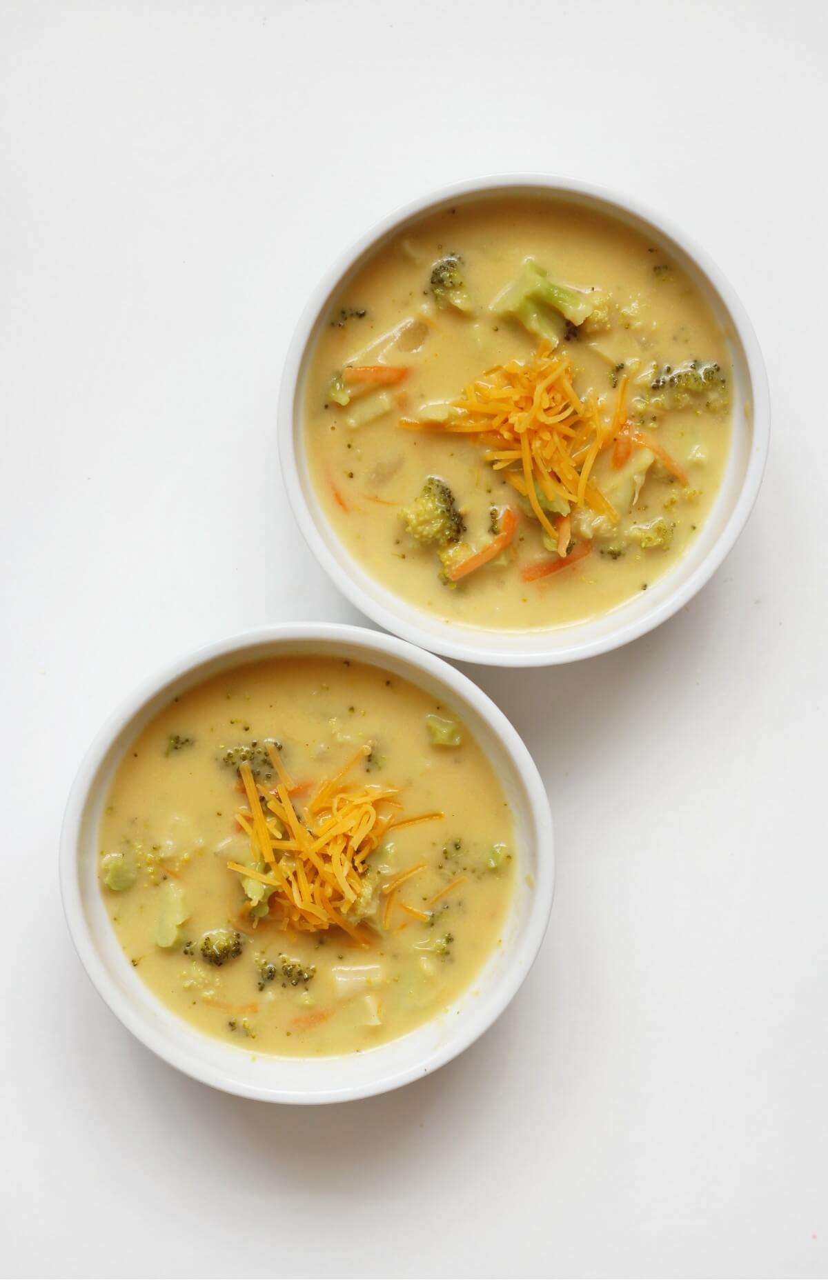 overhead view of two finished bowls of vegan broccoli cheddar soup