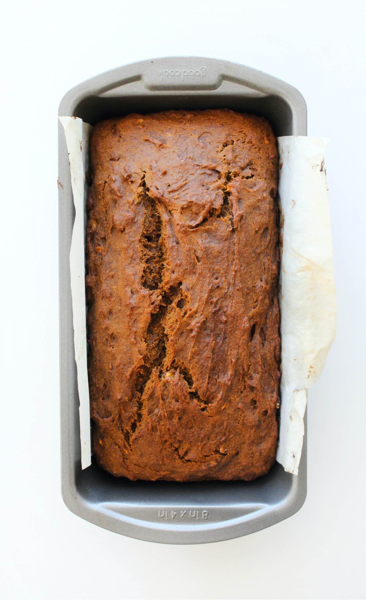 loaf of gingerbread banana bread in bread pan with parchment lining