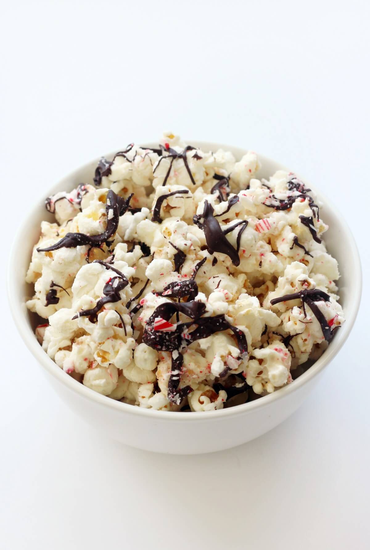 white serving bowl filled with homemade white chocolate peppermint bark popcorn