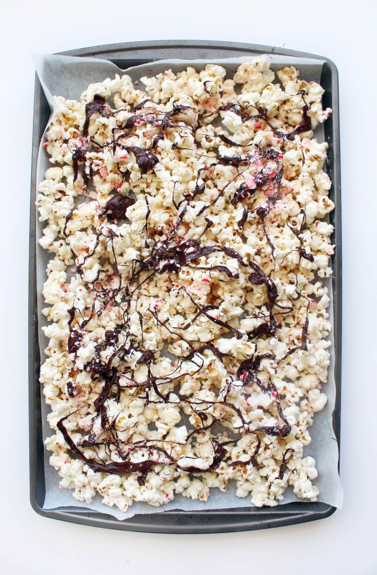 sheet pan with drizzled peppermint bark popcorn