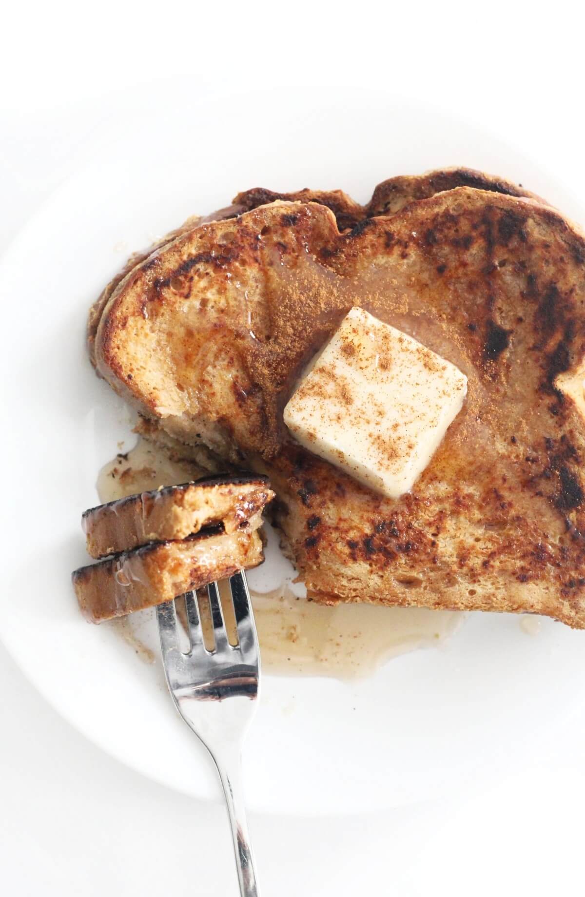 overhead view of eggless french toast on plate with forkful