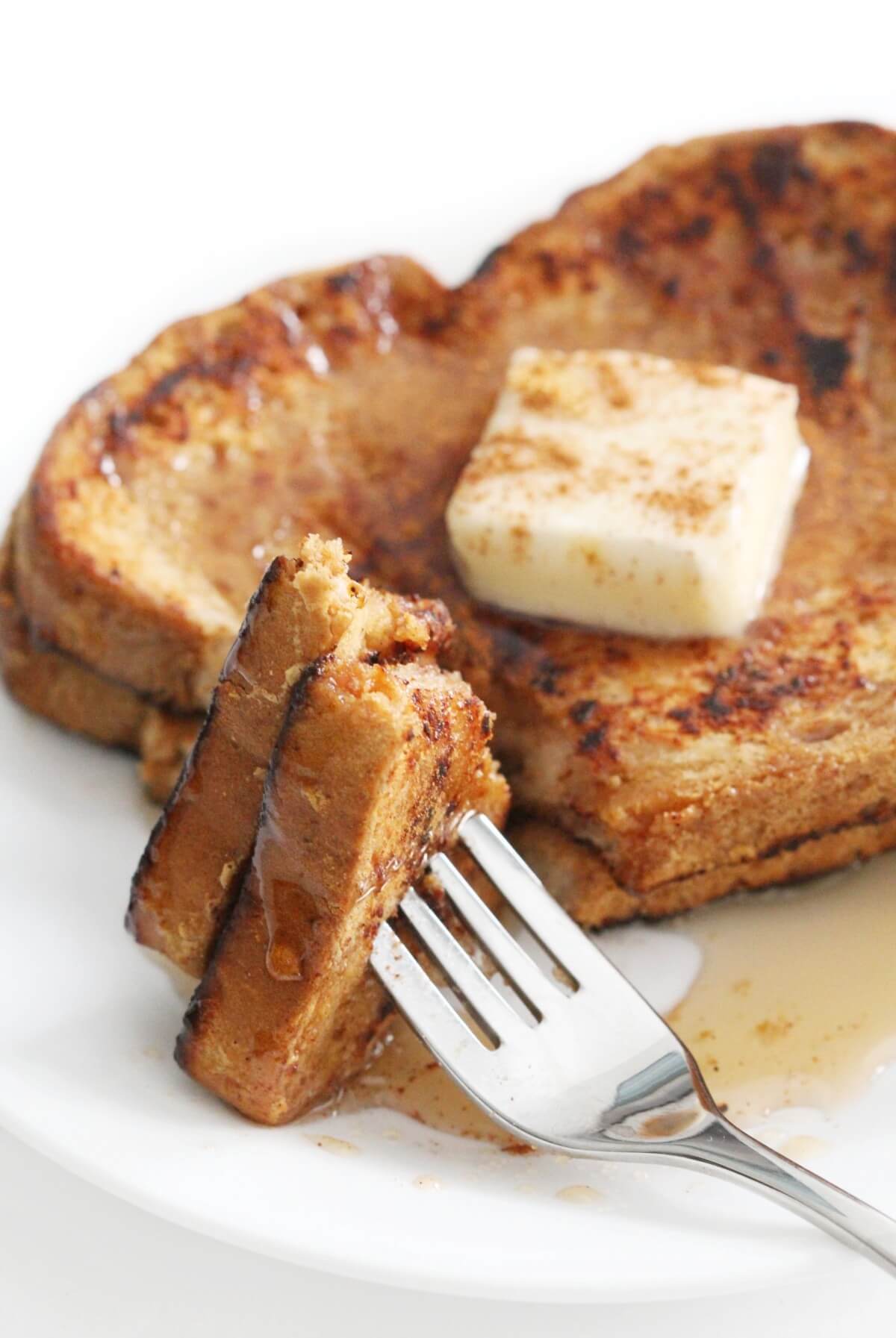 close up of forkful of vegan french toast with maple syrup and cinnamon
