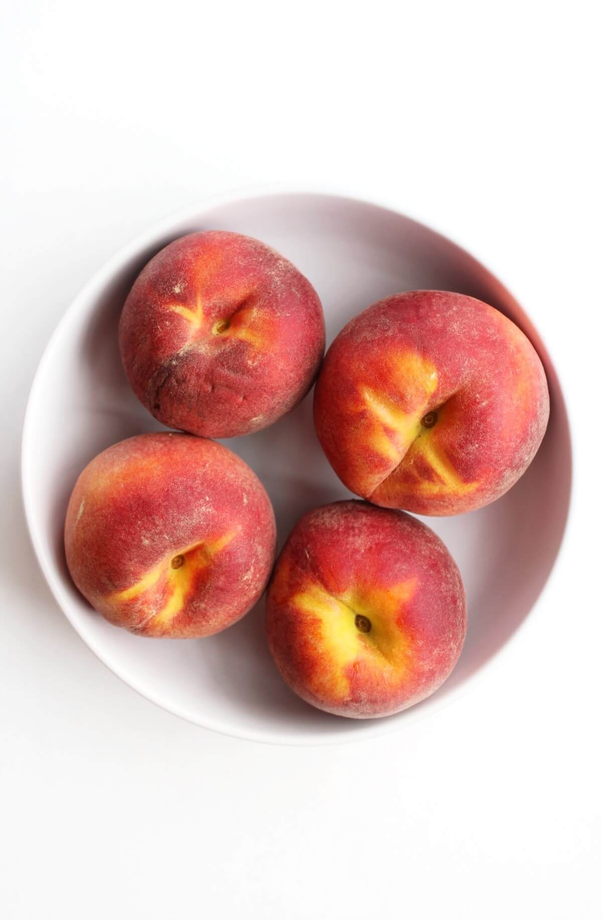 whole yellow peaches in bowl