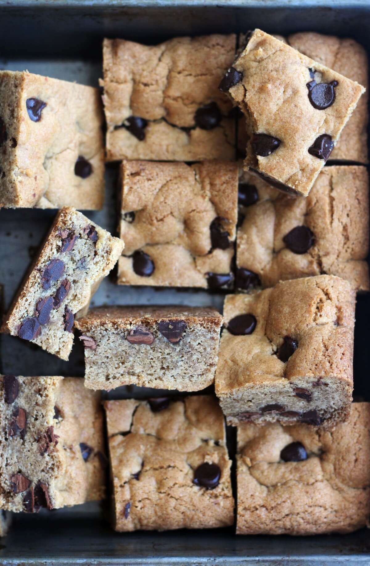 baking pan with cut gluten-free chocolate chip cookie bars tossed about