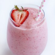 single glass of strawberry pina colada with strawberry and straw