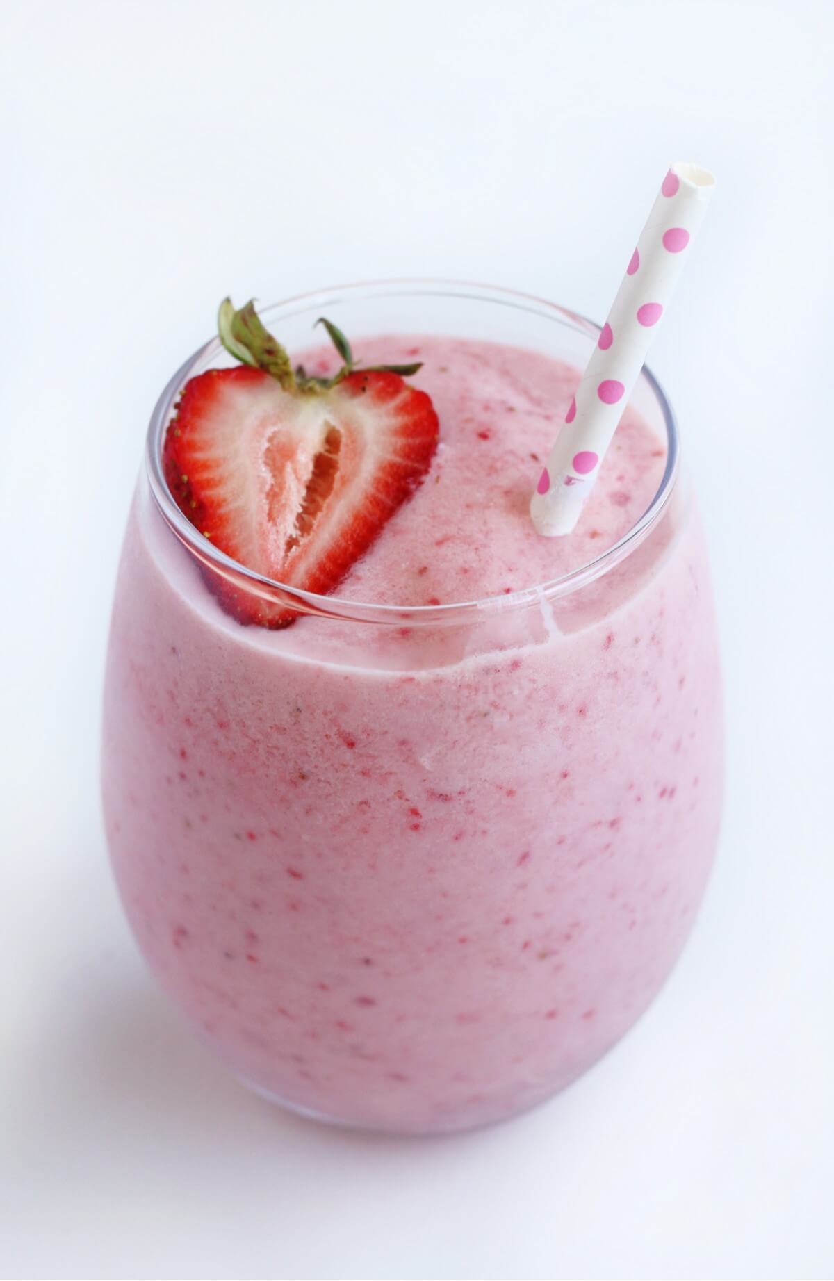 single glass of strawberry pina colada with strawberry and straw