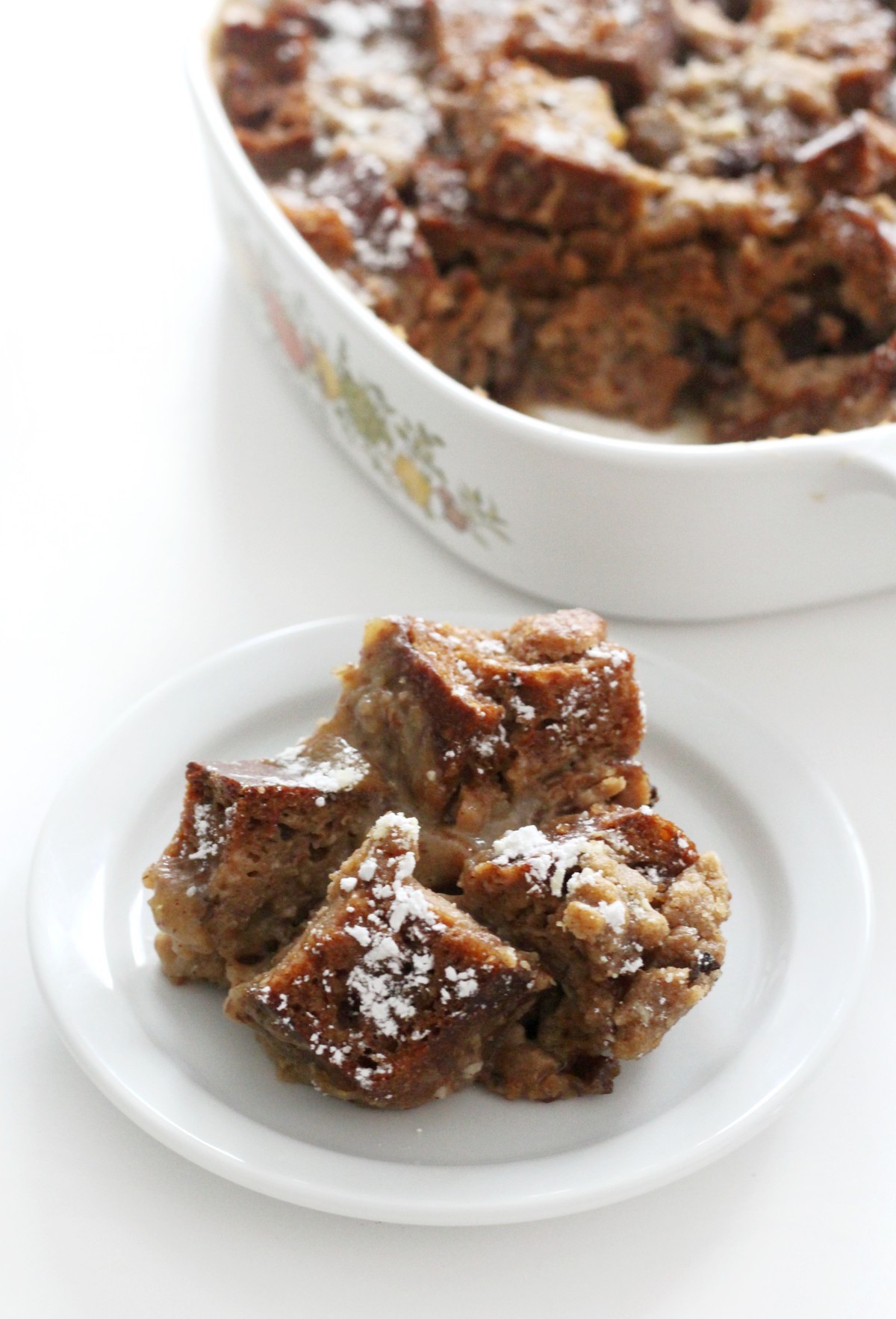 serving of gluten-free french toast casserole on plate with casserole dish in background