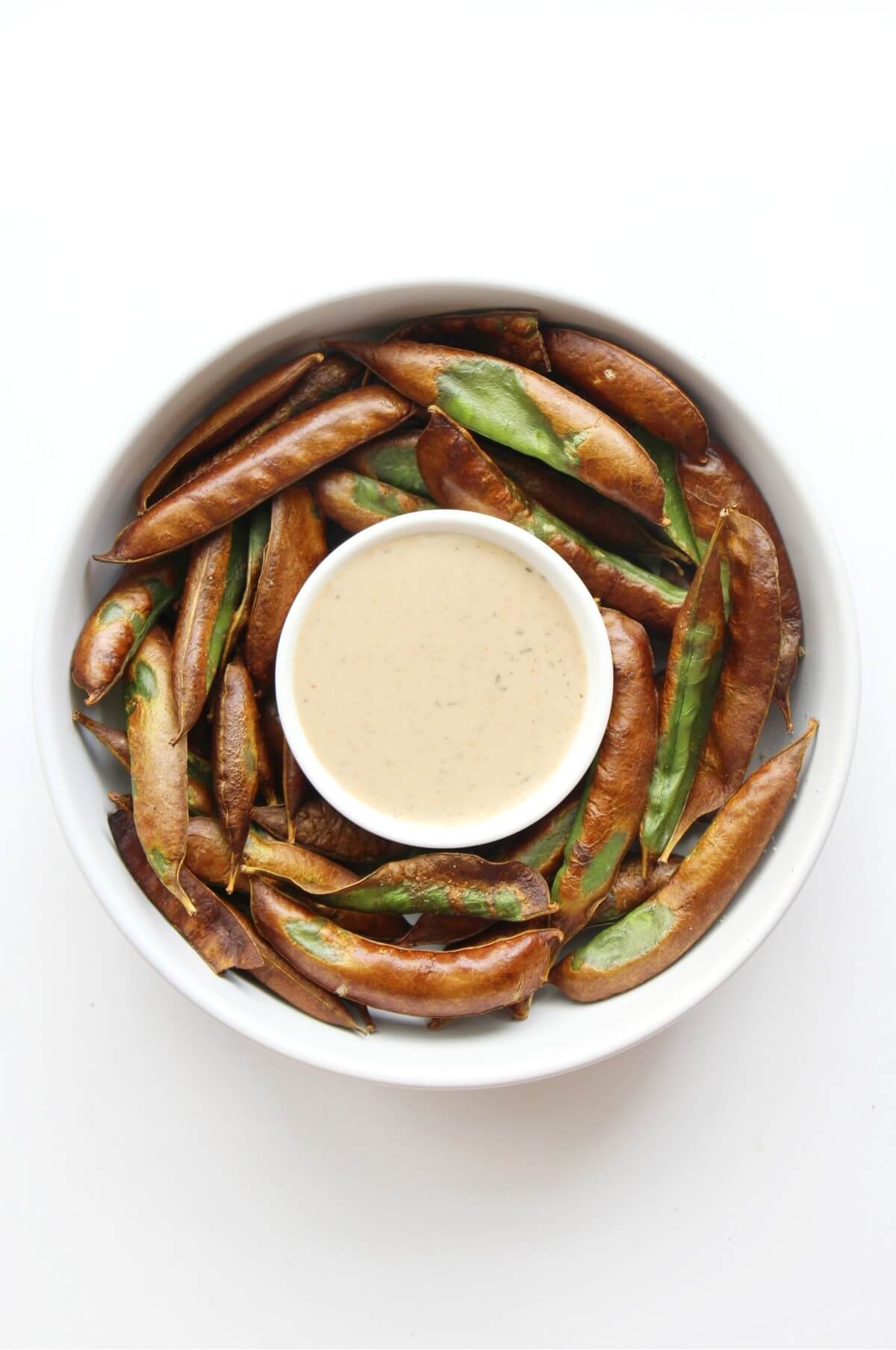 crispy air fryer snow peas in bowl with dipping sauce