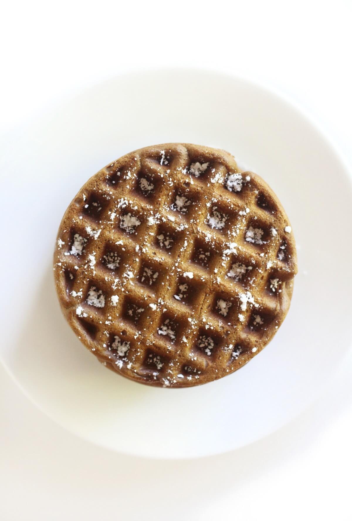 overhead view of stacked gingerbread waffles with powdered sugar