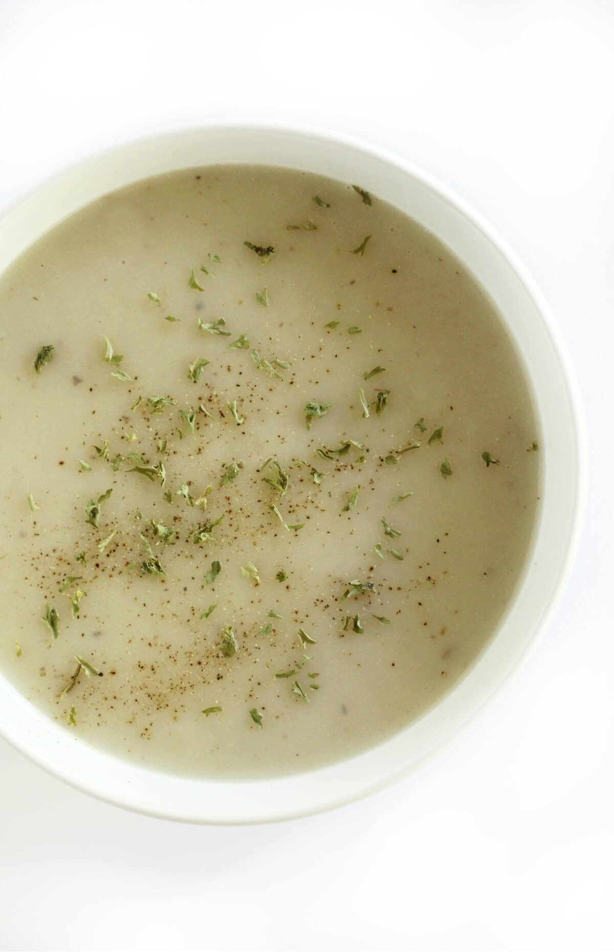 overhead view of half a bowl of vegan cream of malanga soup