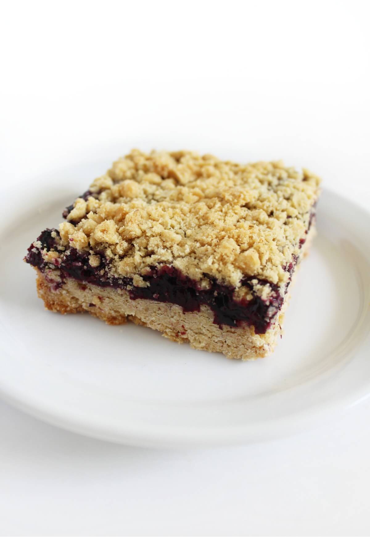 single gluten-free blueberry crumble bar on white plate