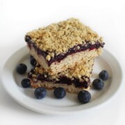 plate of two gluten-free blueberry crumble bars with extra blueberries