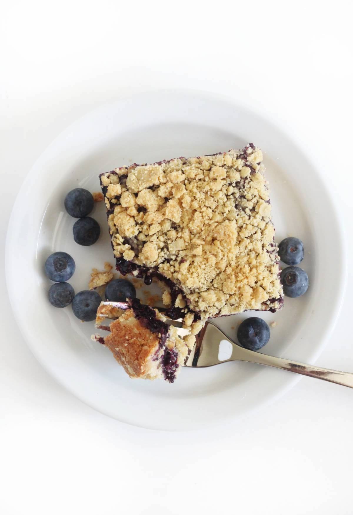 overhead view of gluten-free blueberry jam crumb bar with forkful