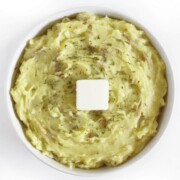 creamy vegan garlic mashed potatoes in serving bowl with butter.
