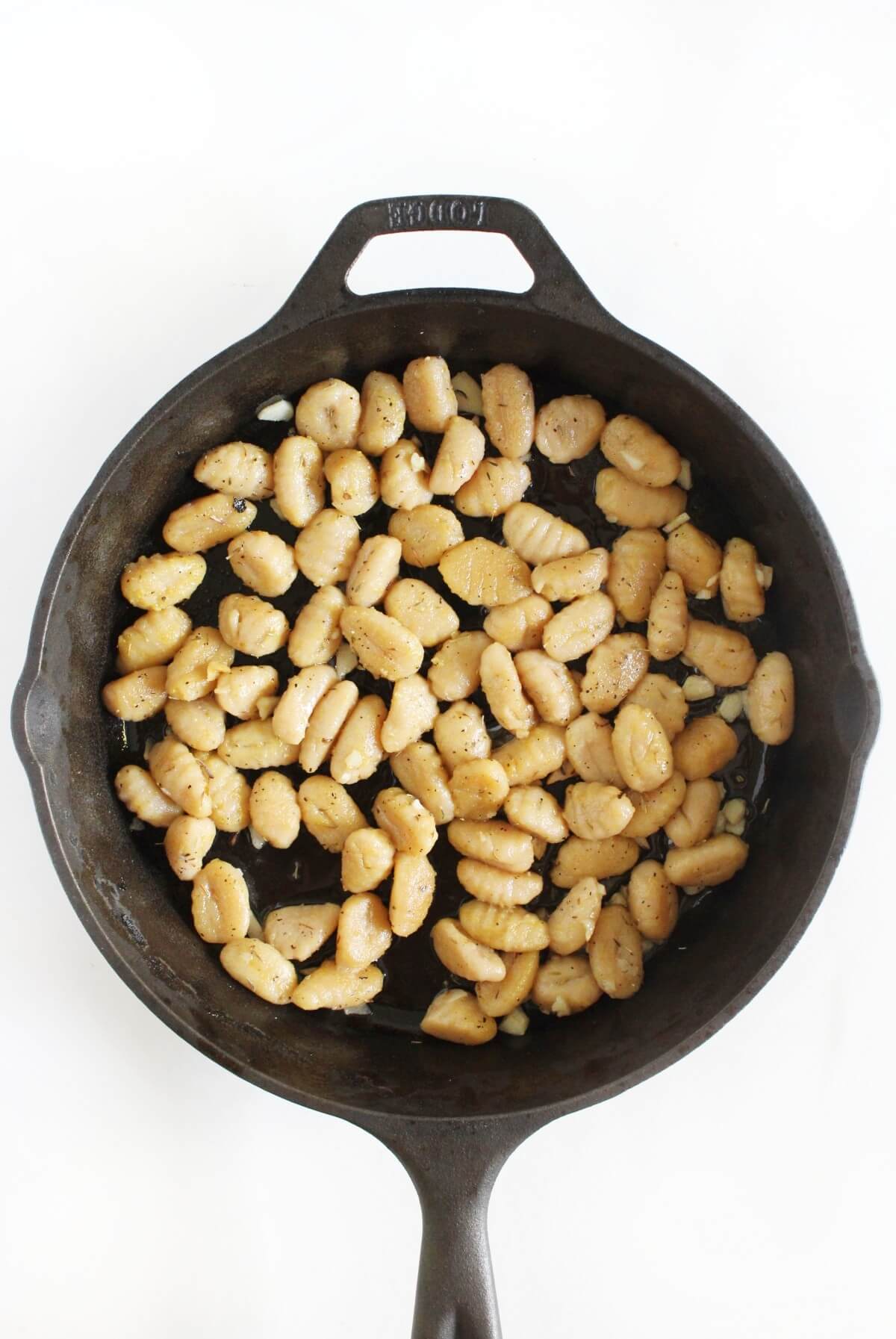 gluten-free gnocchi with butter garlic sauce in cast iron pan.