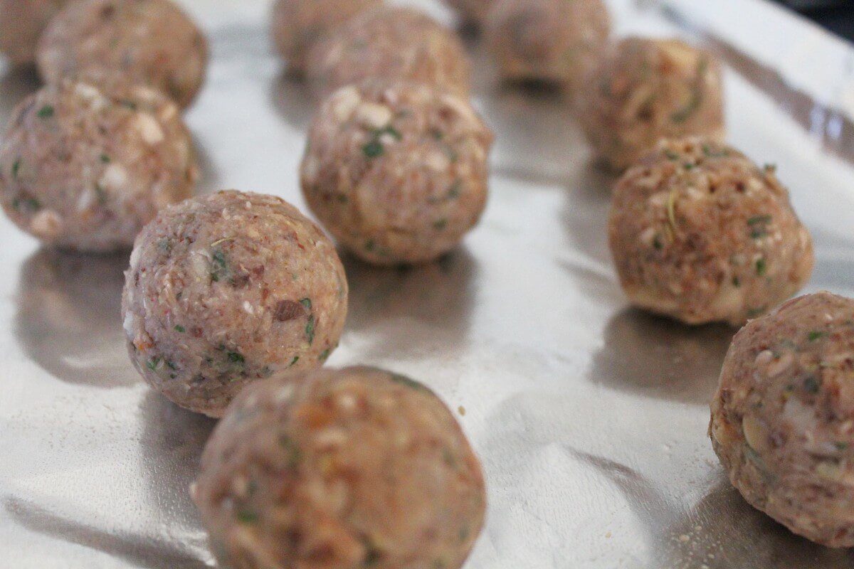 rolled bean meatballs on baking sheet.