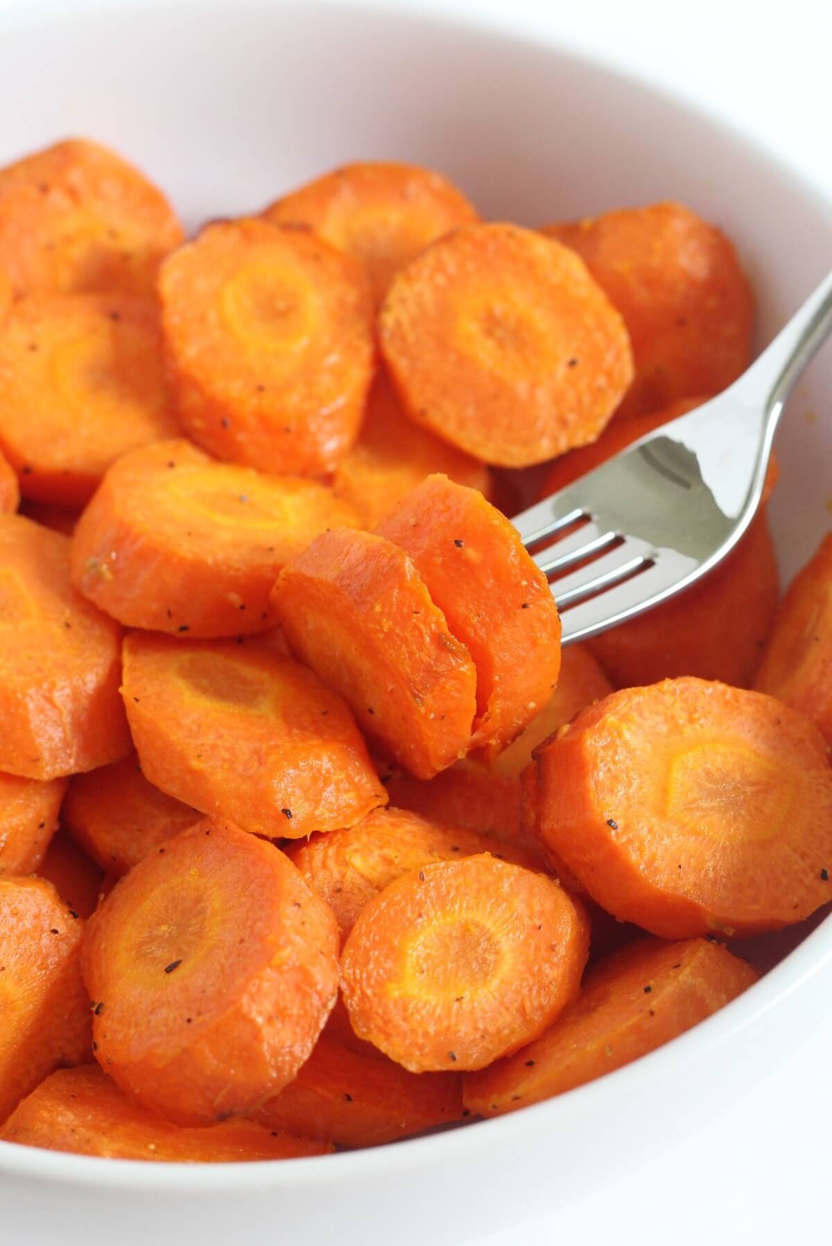 forkful of air fryer carrots in bowl.