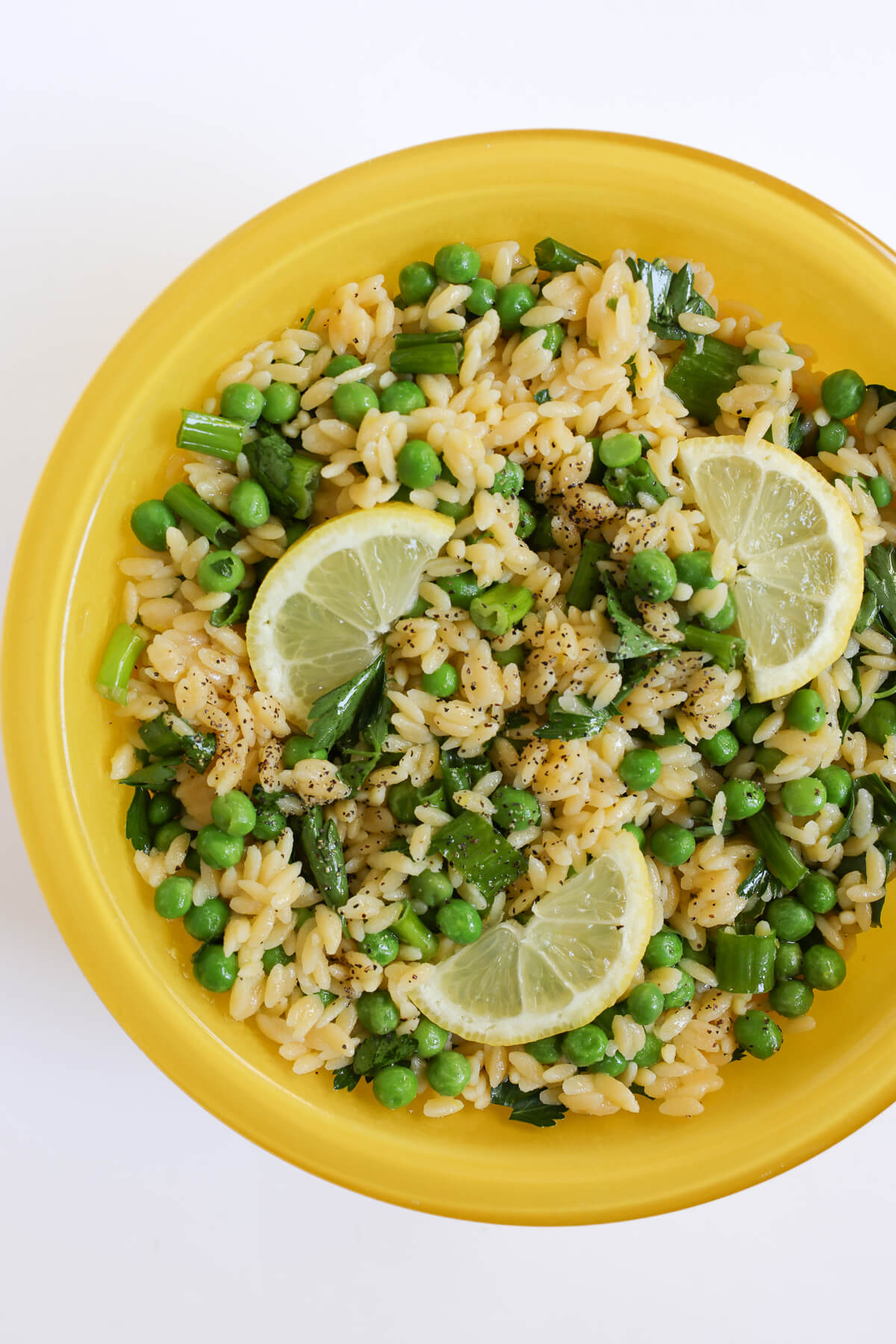 spring orzo pasta salad in yellow mixing bowl.