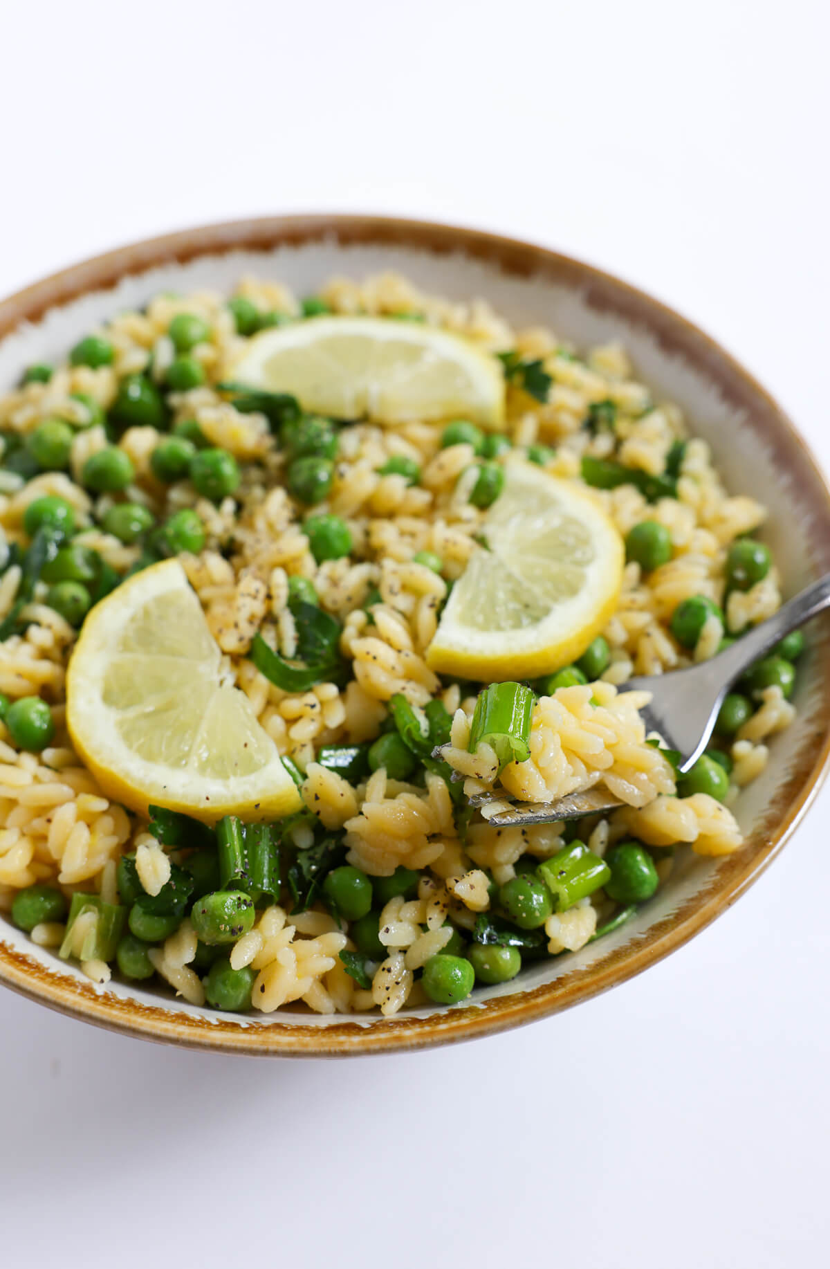 forkful of spring orzo pasta salad with peas.