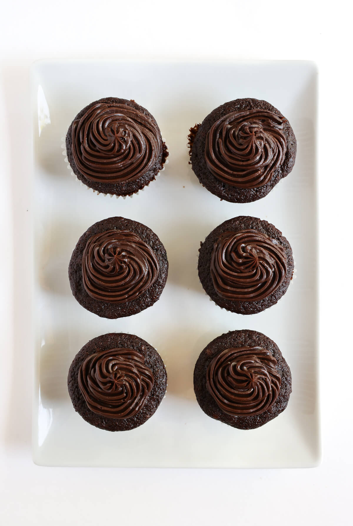 overhead view of vegan chocolate buttercream frosted cupcakes.