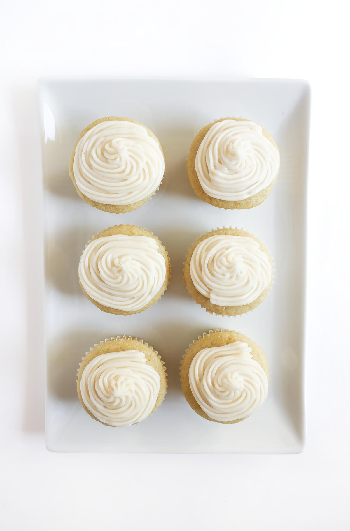 overhead view of plate with gluten-free vanilla cupcakes and vegan buttercream frosting.