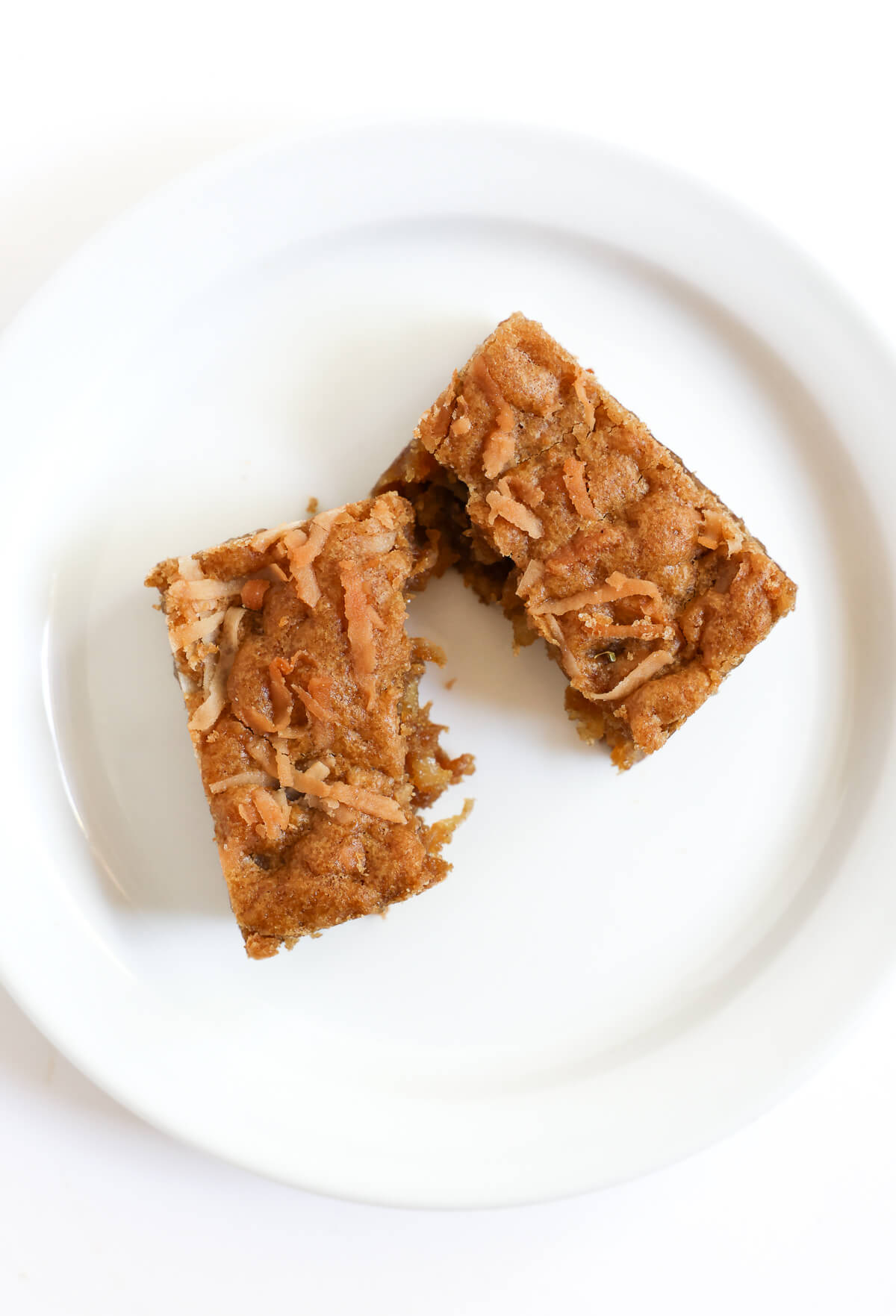 overhead view of split apart chewy coconut bar on plate.