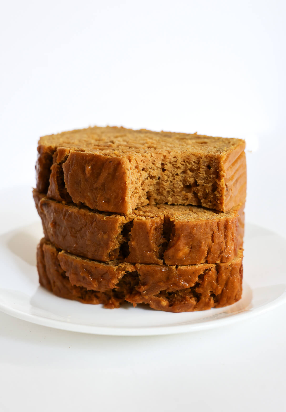 three slices of gluten-free pumpkin banana bread with a bite in top slice.