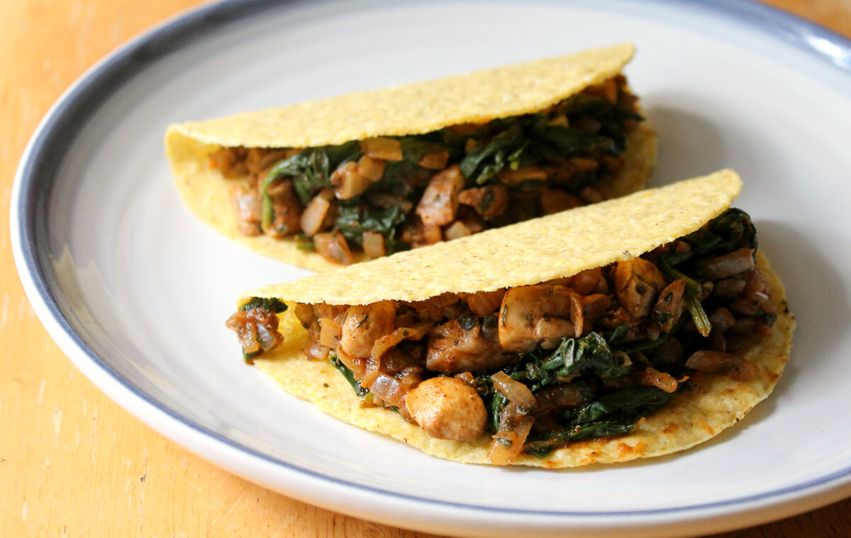 two vegan pumpkin lentils tacos in gluten-free corn tortilla shells on plate.