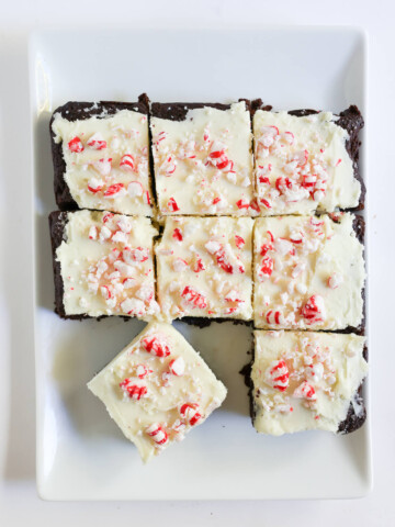 sliced peppermint bark brownies on serving plate.