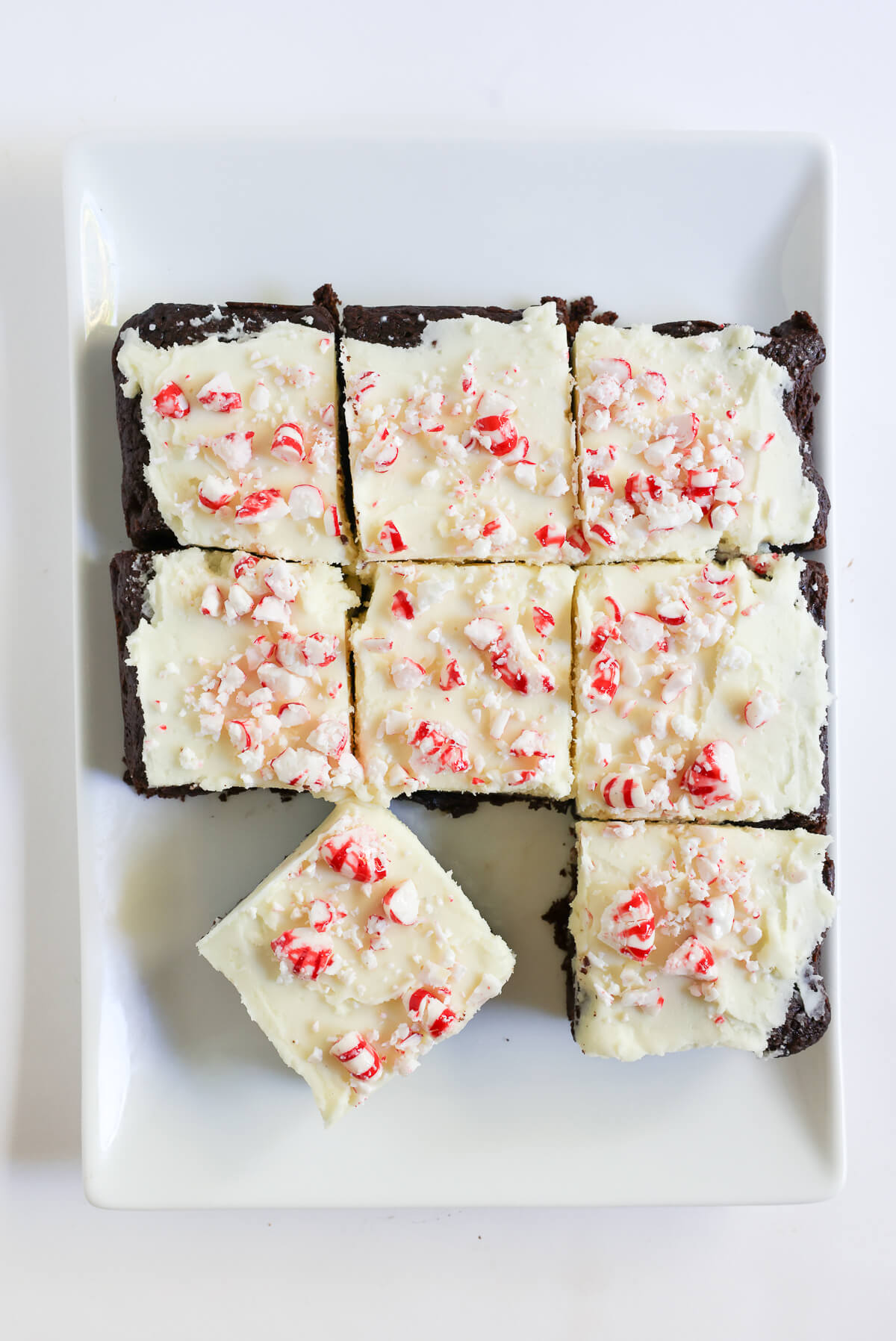 sliced peppermint bark brownies on serving plate.