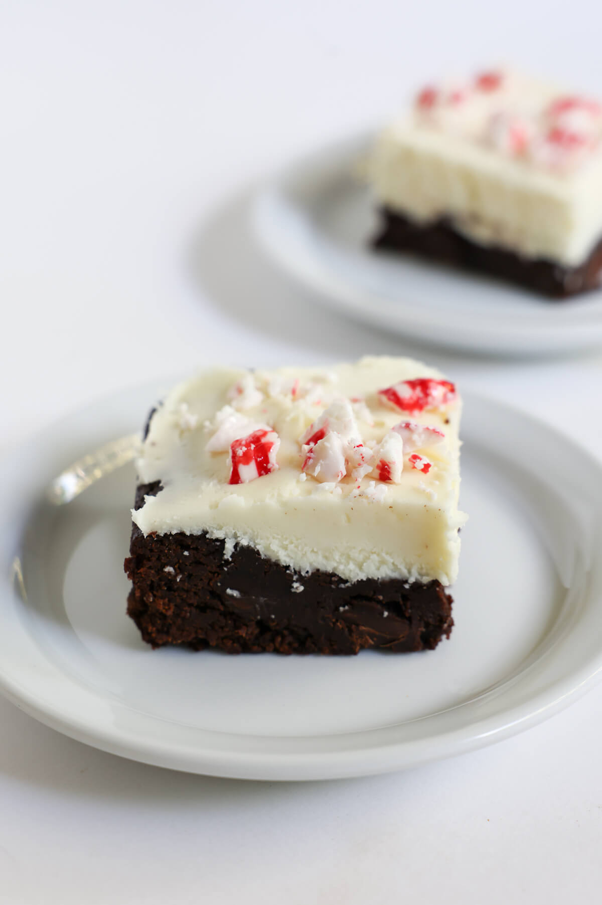 side view of layers in peppermint bark brownies with frosting.