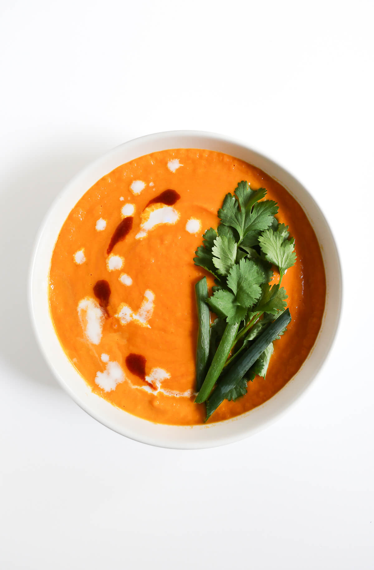 ready to serve bowl of thai carrot soup with toppings.